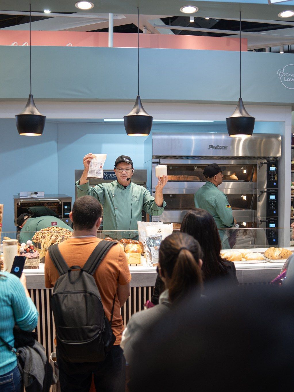 Um homem com uniforme de chef está fazendo uma apresentação para um grupo de pessoas