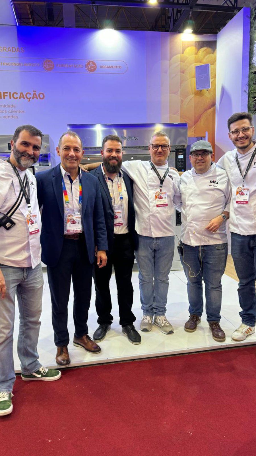 Um grupo de homens está posando para uma foto em uma convenção.