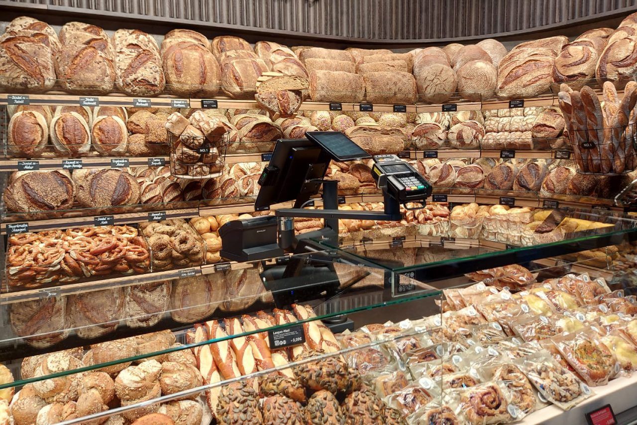 Uma vitrine de padaria cheia de pães e doces.