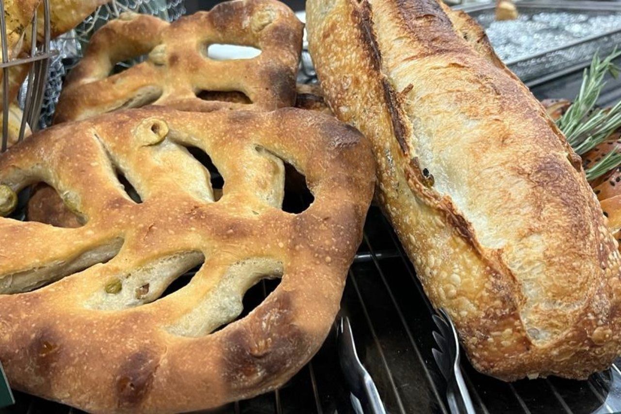 Há muitos tipos diferentes de pão na mesa.