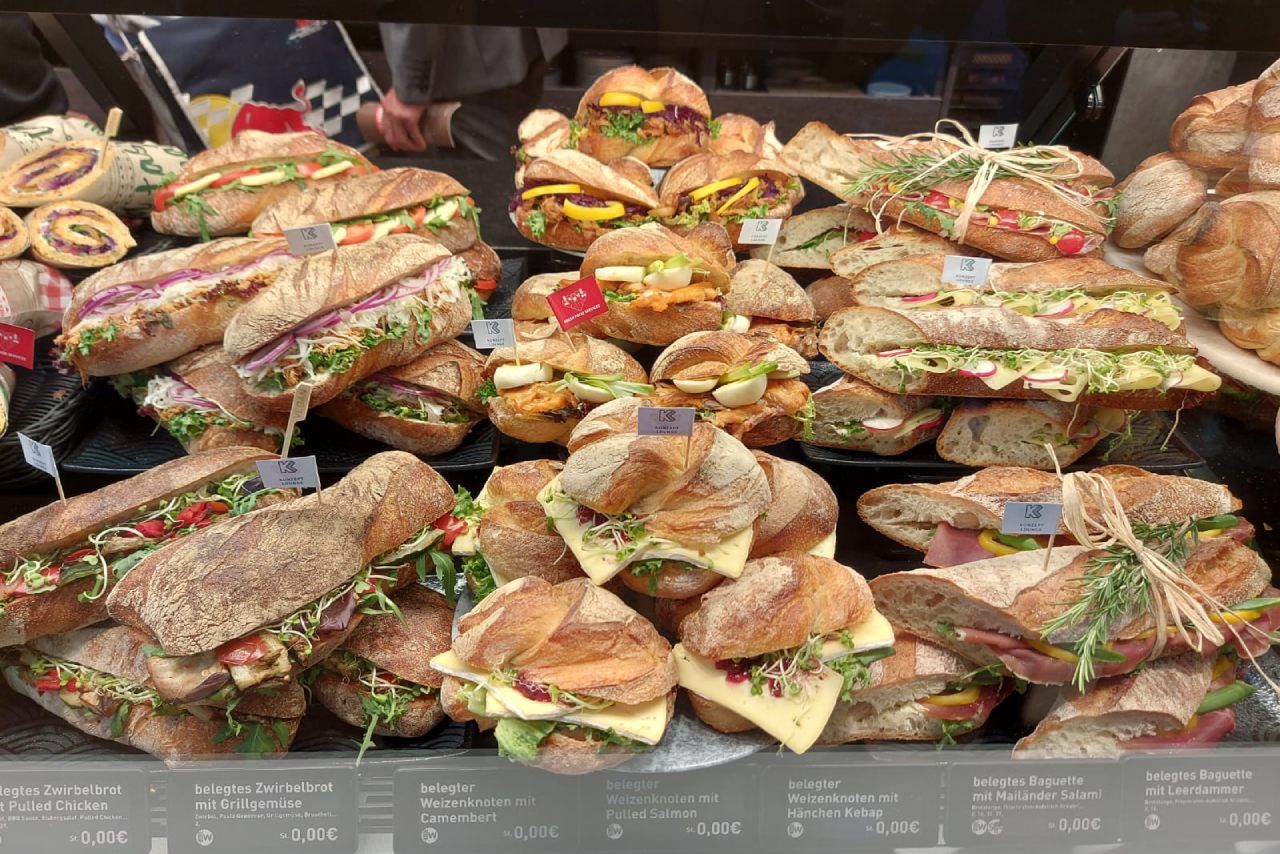 Uma variedade de sanduíches estão em exposição em uma padaria.