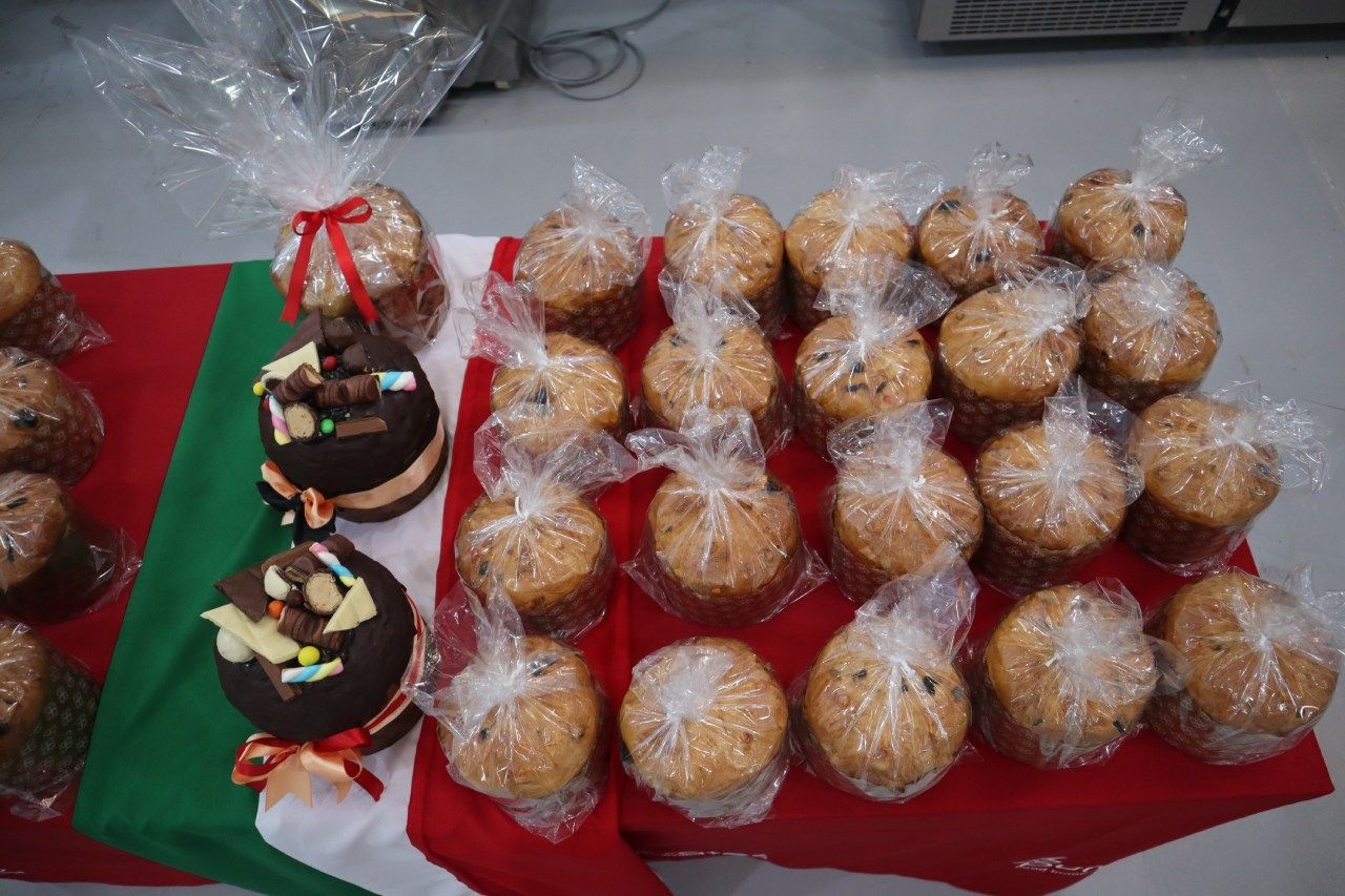 Uma mesa coberta com muitos cupcakes embrulhados em plástico.