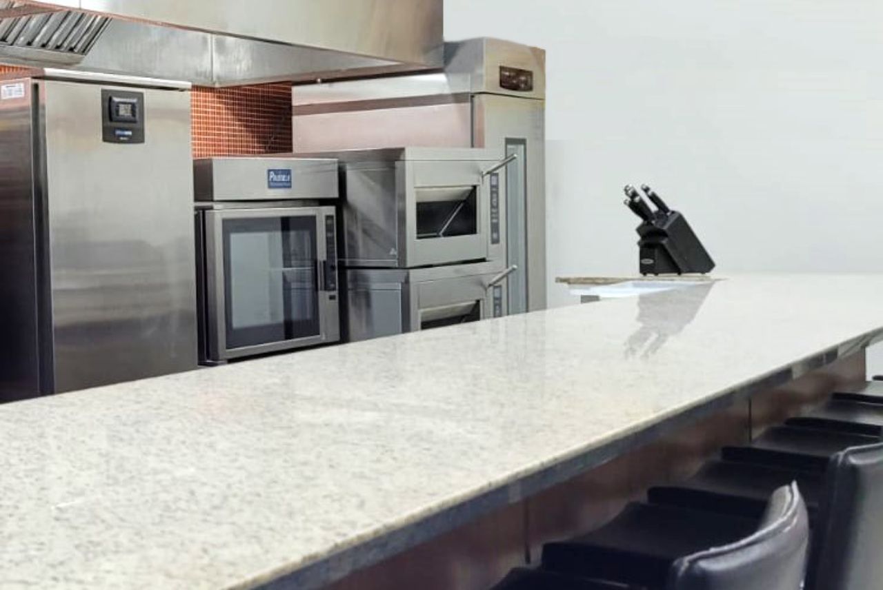 Uma cozinha com eletrodomésticos de aço inoxidável e uma bancada de granito