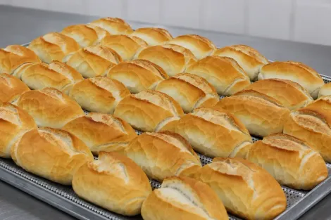Bandeja de pães franceses dourados recém-assados ​​em uma assadeira de metal