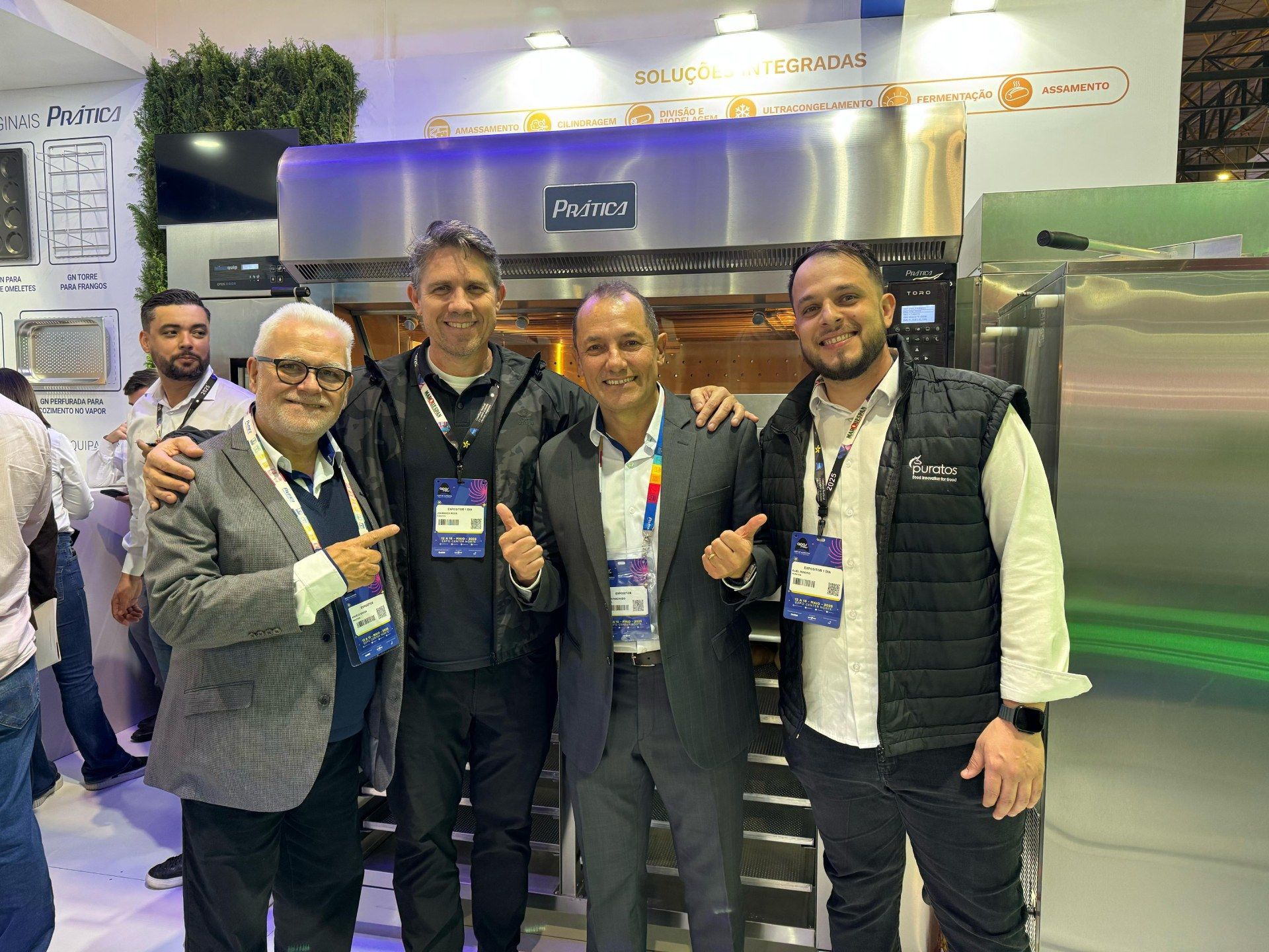 Um grupo de homens está posando para uma foto em frente a um forno.