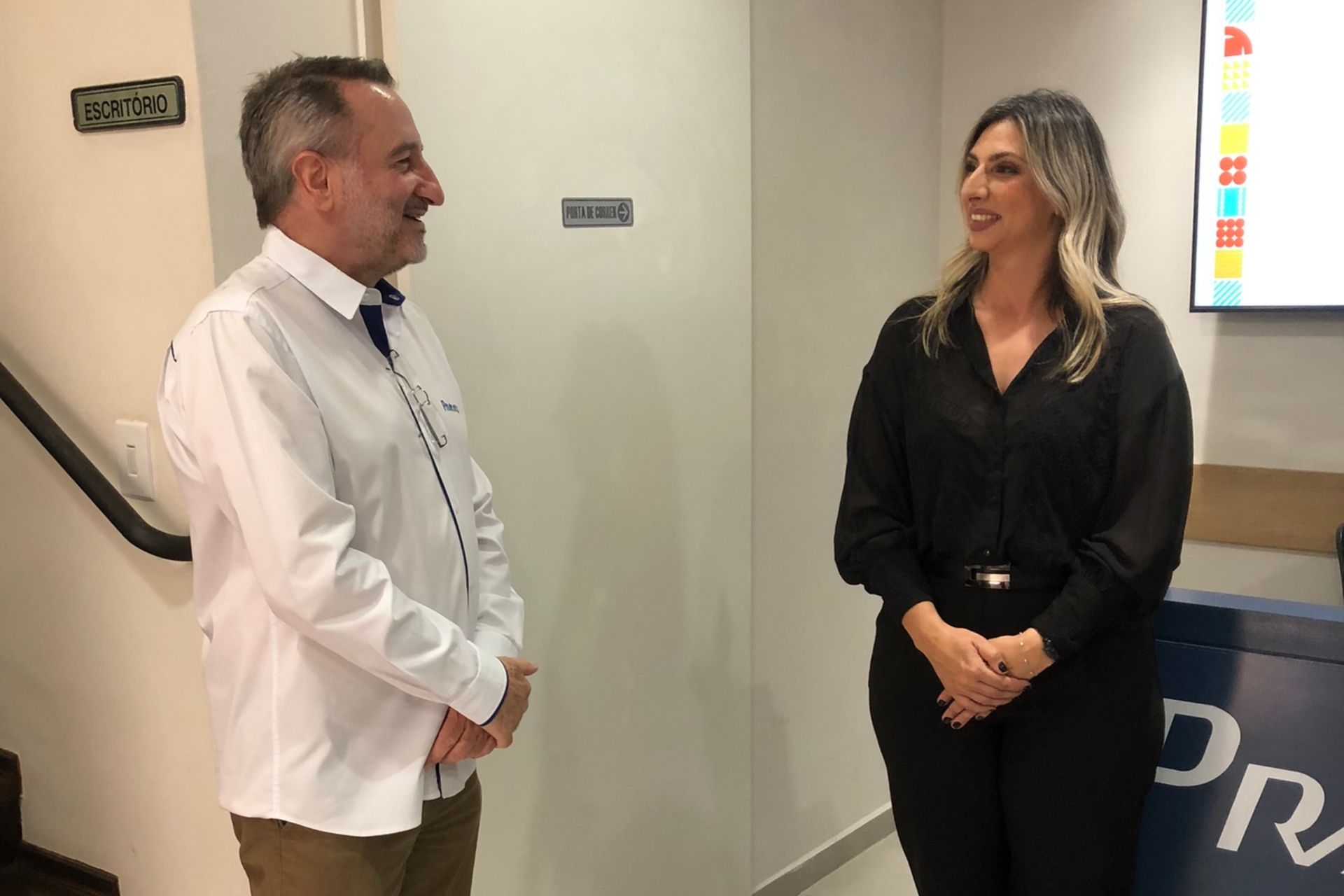 Homem e mulher sorrindo, frente a frente