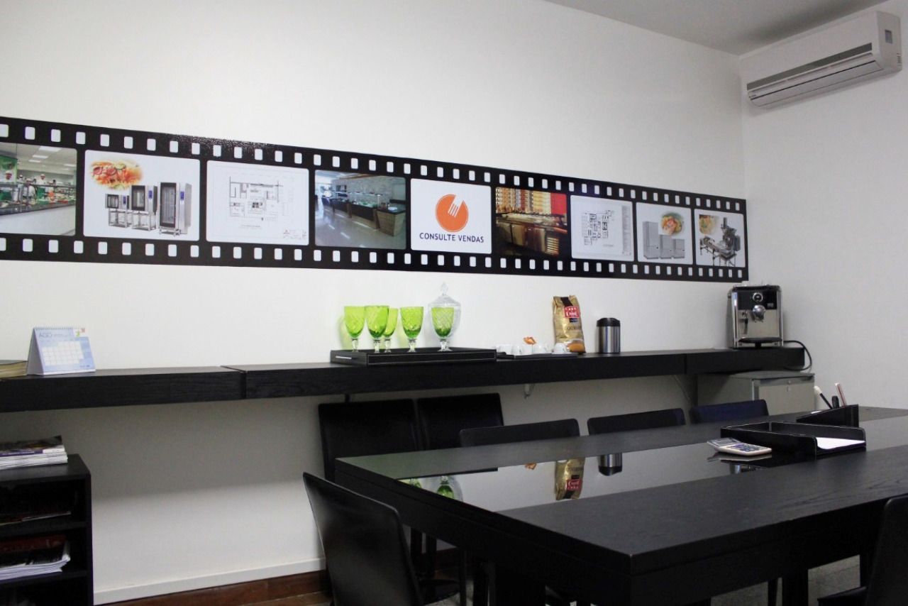 Uma sala com uma mesa e cadeiras e uma película de filme na parede