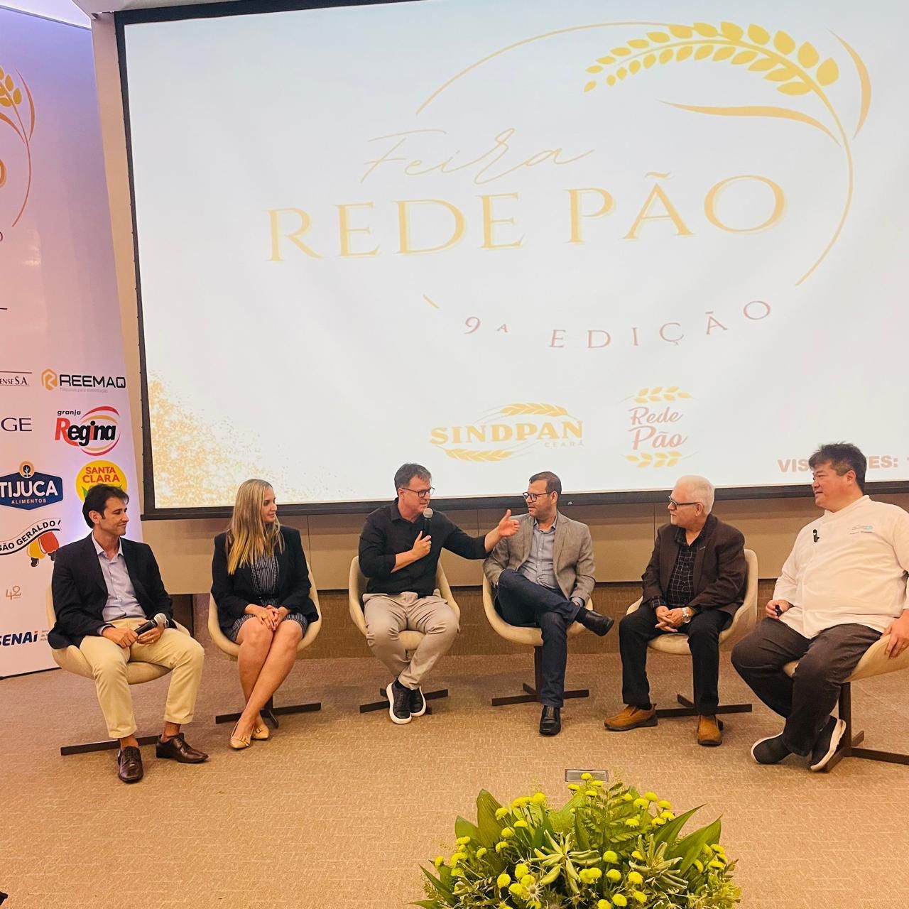 Um grupo de pessoas sentadas em frente a uma tela que diz rede pao