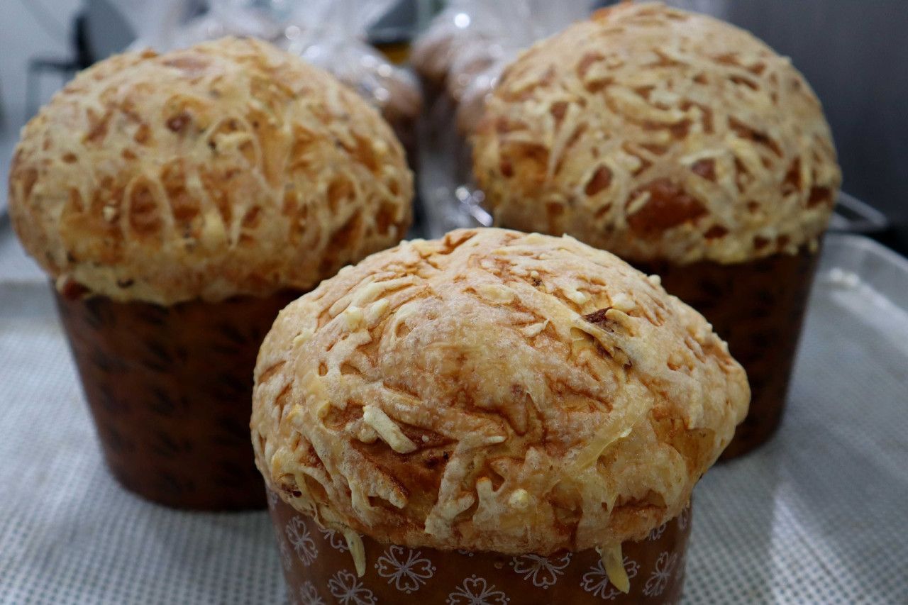 Três muffins com queijo por cima estão em uma bandeja.