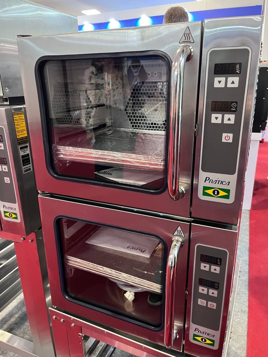 Dois fornos de aço inoxidável estão empilhados um sobre o outro.