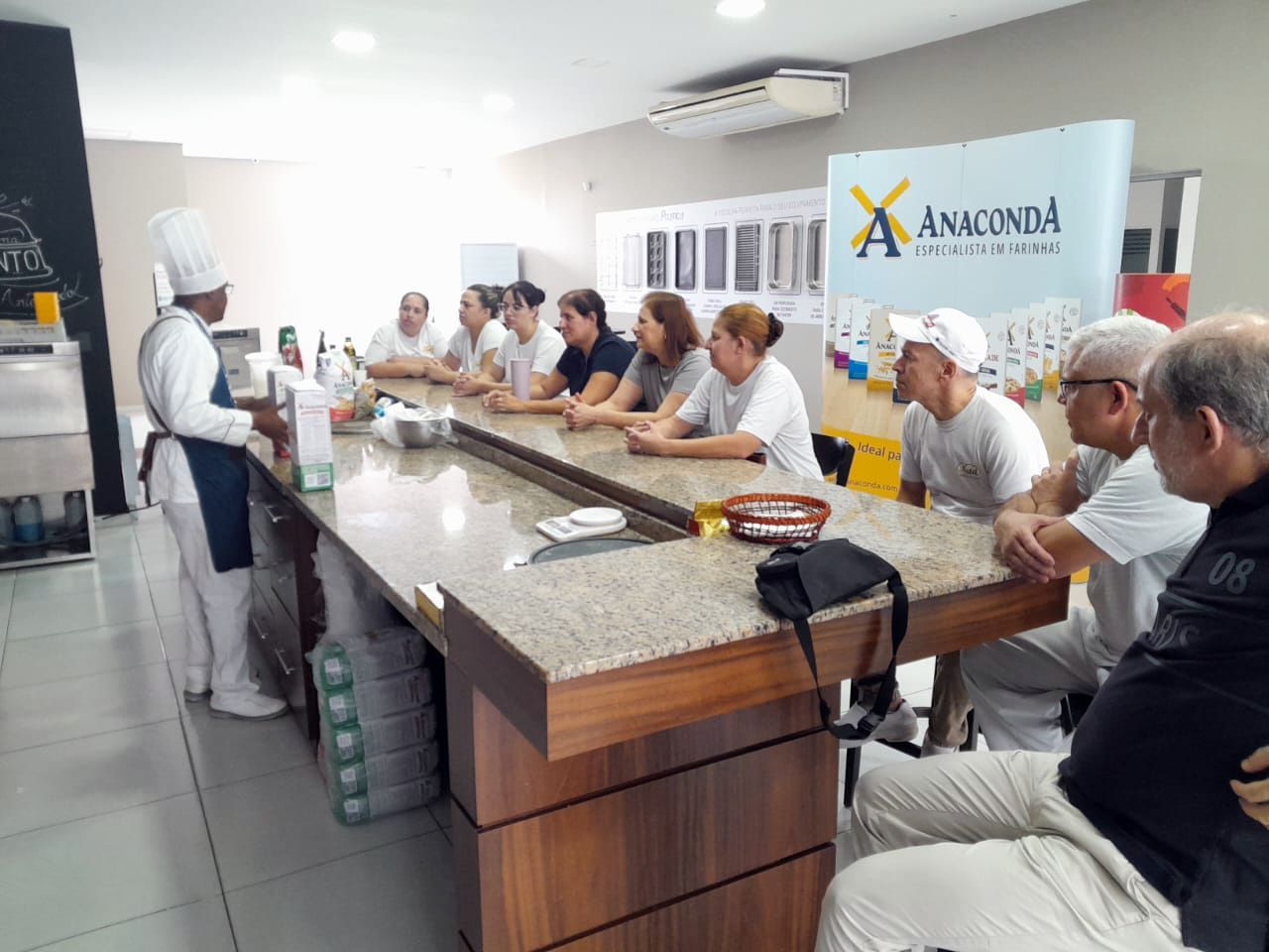 Um grupo de pessoas está sentado à mesa na cozinha.