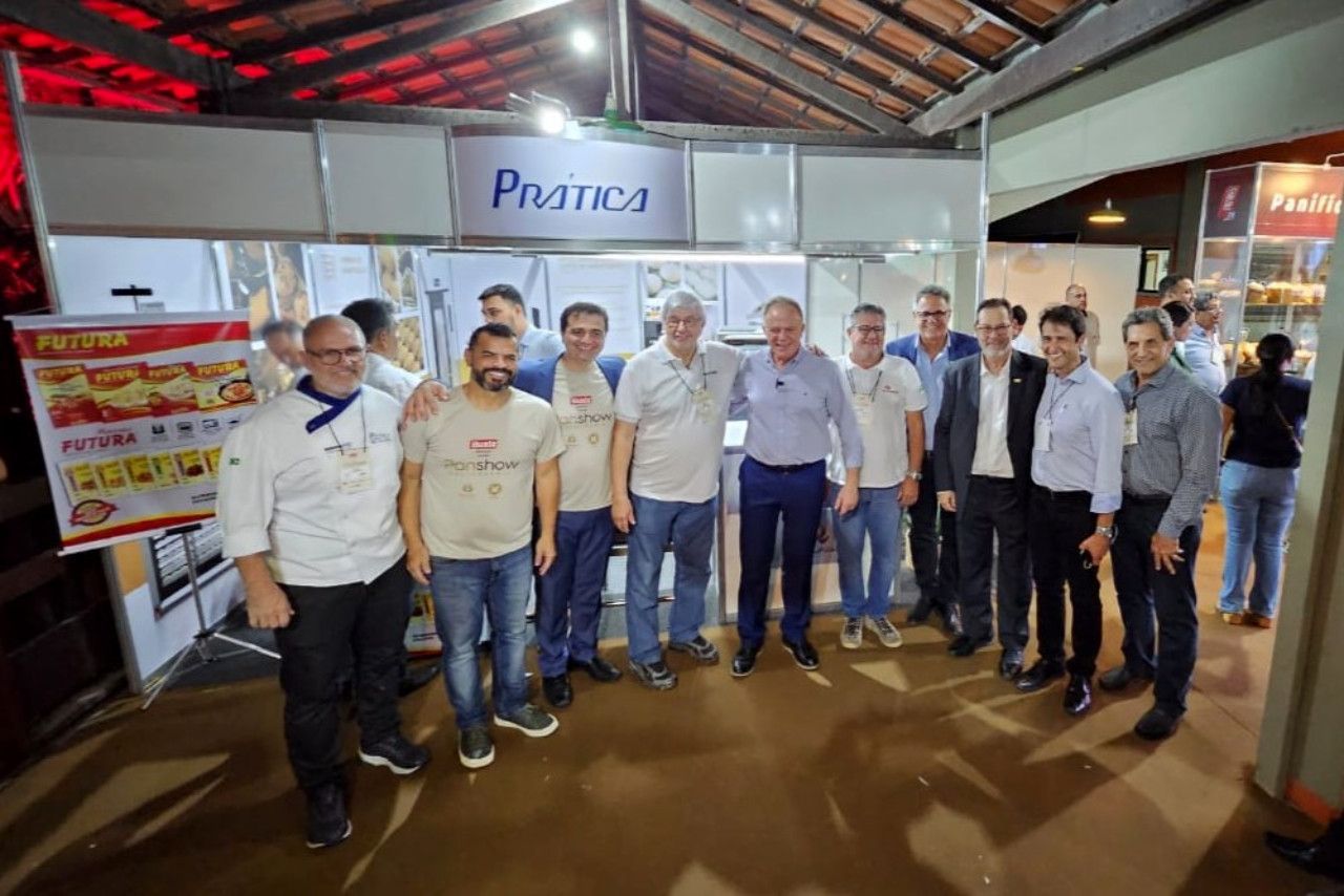 Um grupo de homens está posando para uma foto em frente a uma cabine.