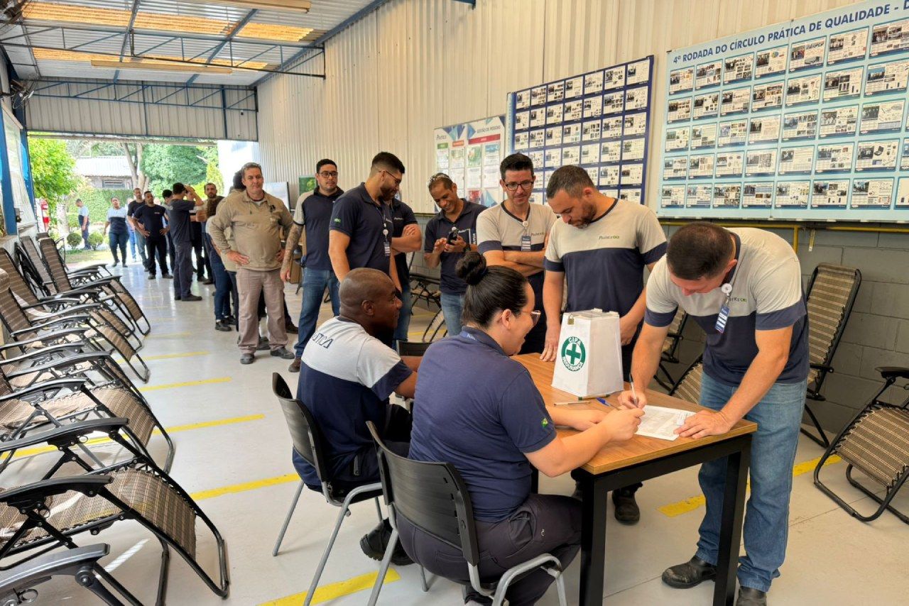 Um grupo de pessoas está sentado à mesa em uma sala.