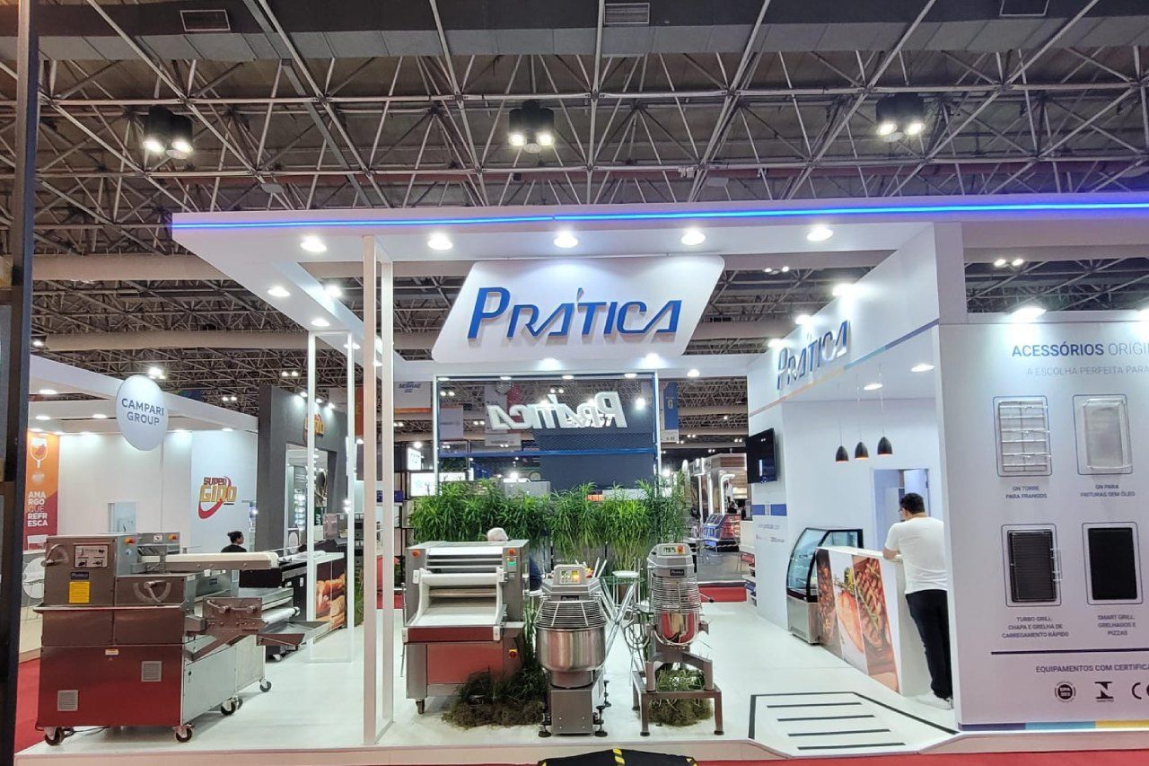 Um homem está em frente a um estande de prática em uma convenção.