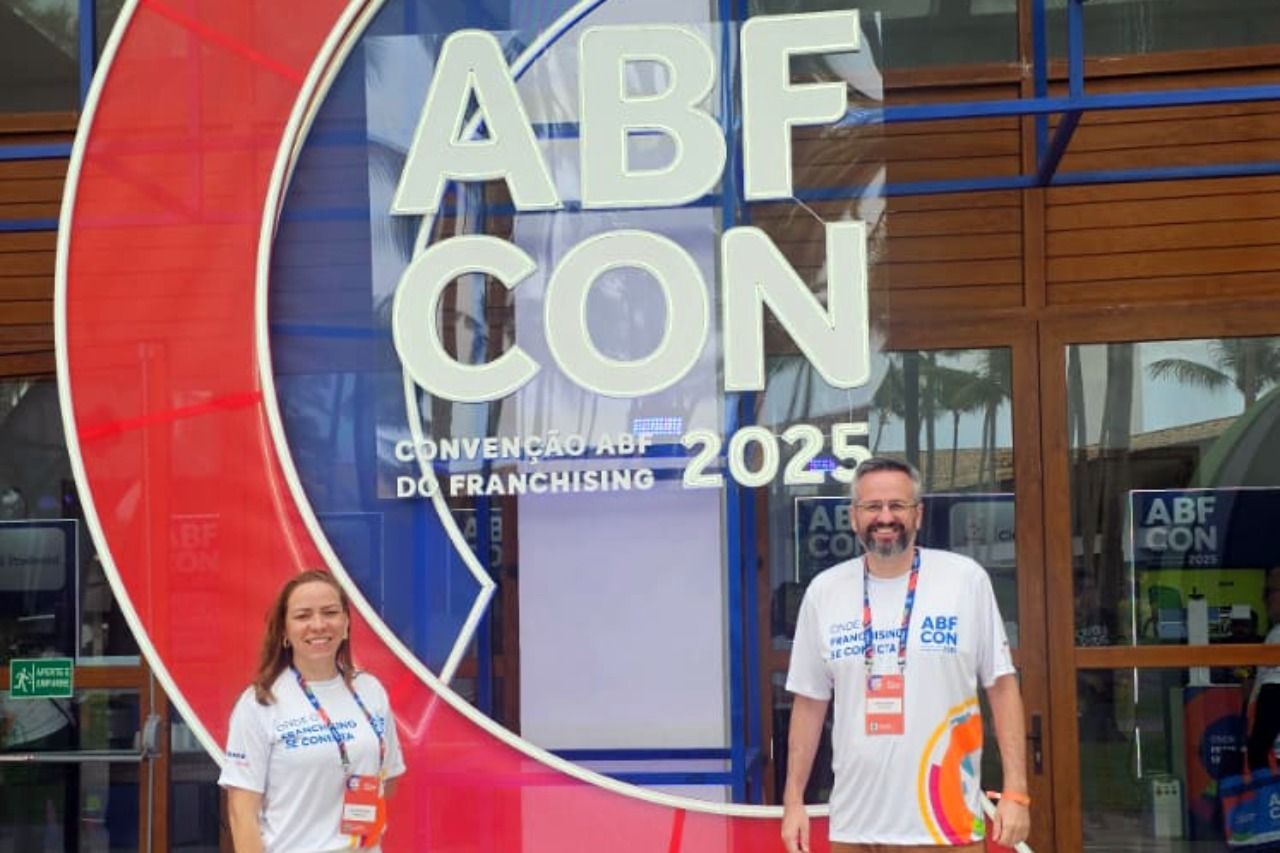 Duas pessoas em frente à placa