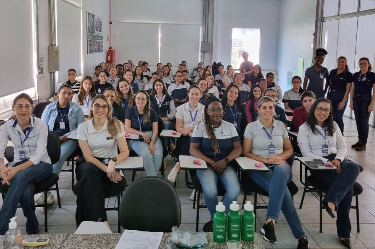 Um grande grupo de pessoas está sentado em uma sala de aula.