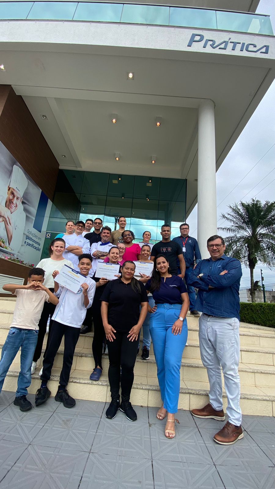 Um grupo de pessoas está posando para uma foto em frente a um prédio.