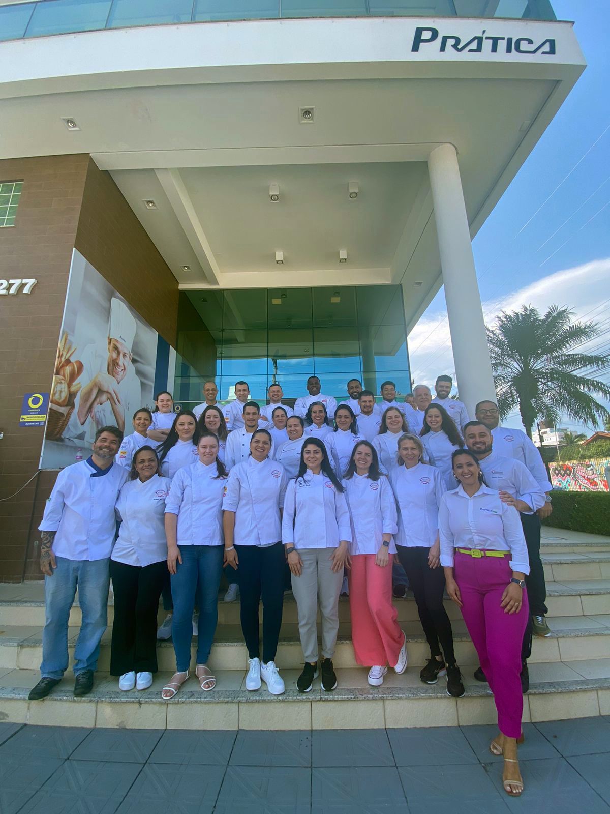 Um grupo de pessoas está posando para uma foto em frente a um prédio.