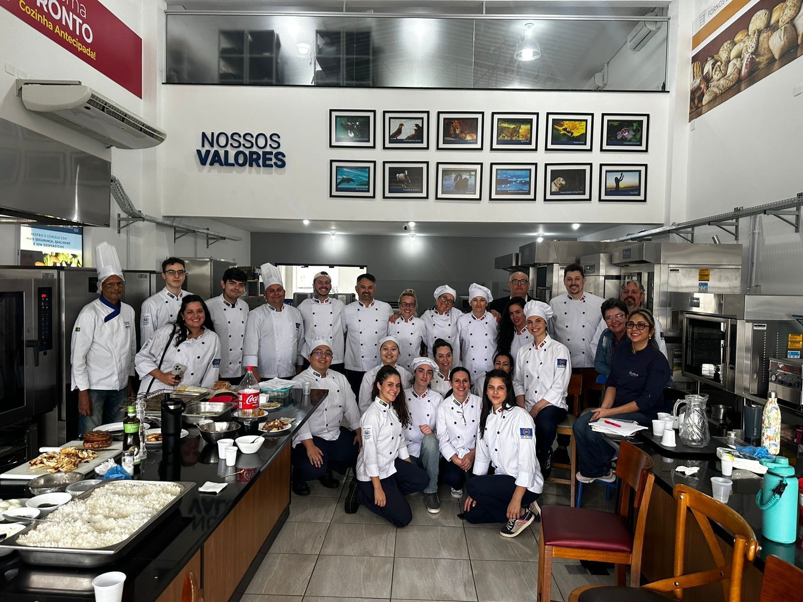 Um grupo de pessoas está posando para uma foto em uma cozinha.