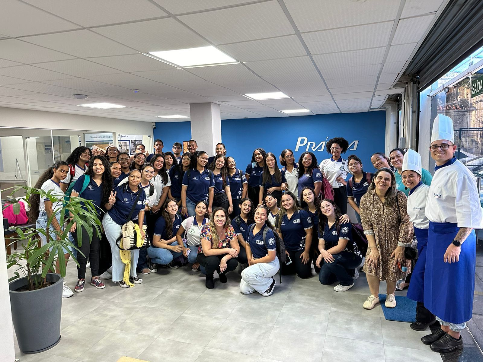 Um grupo de pessoas está posando para uma foto em uma sala.
