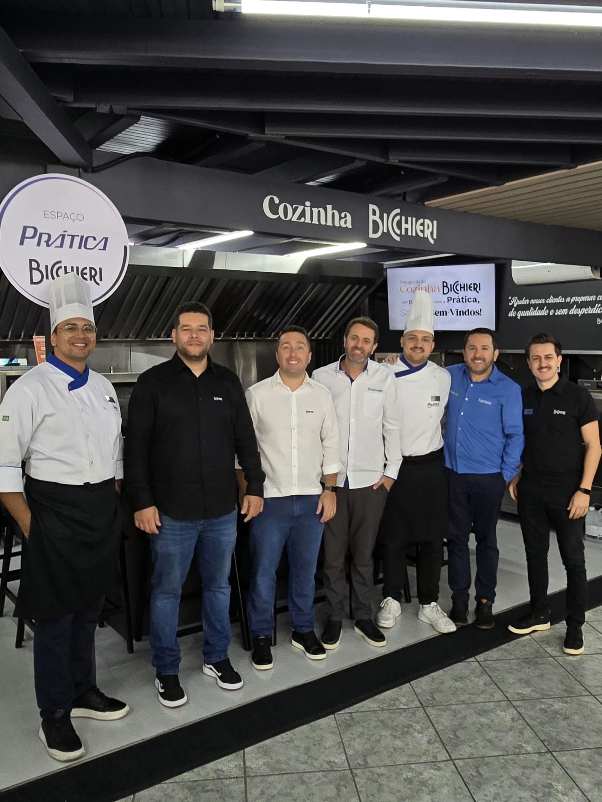 Um grupo de pessoas posando para uma foto em uma cozinha