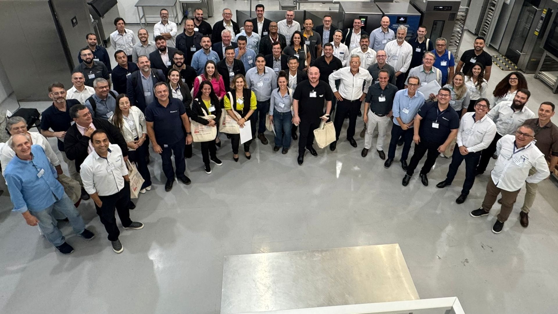 Um grande grupo de pessoas está posando para uma foto em uma sala.