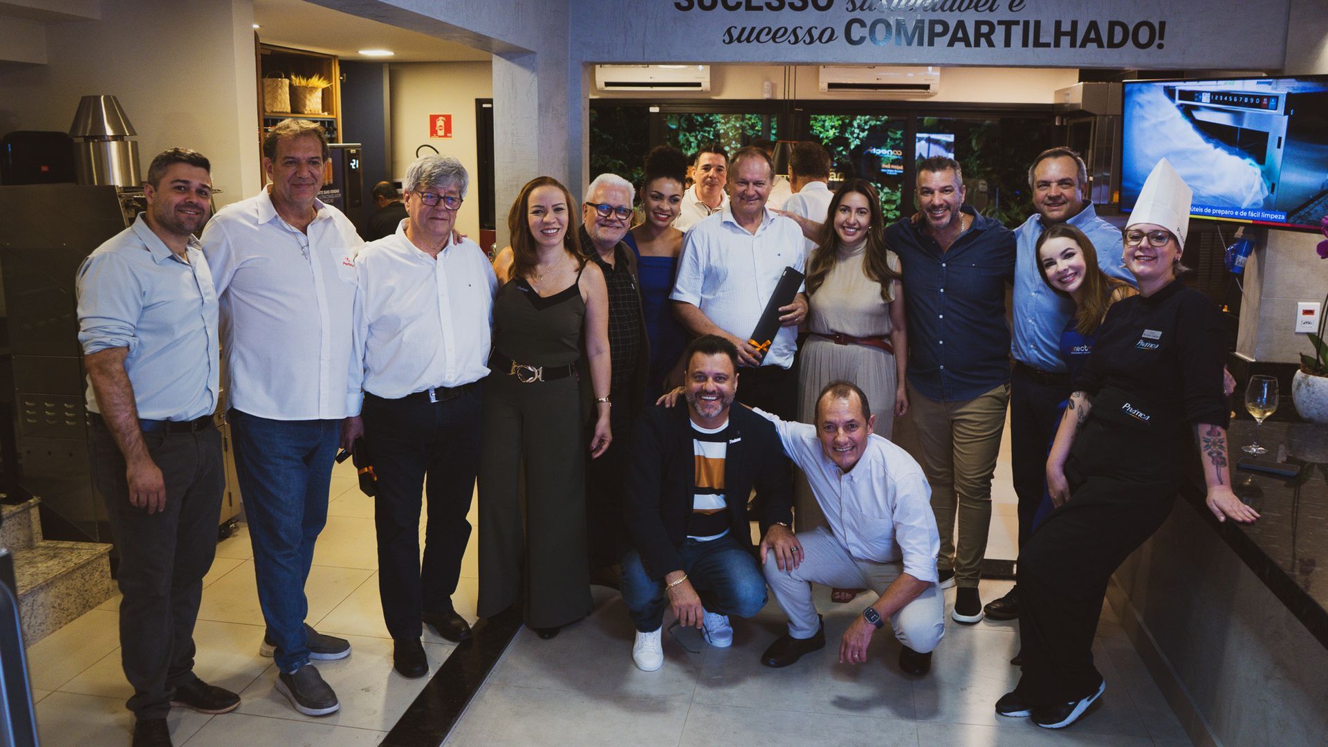 Um grupo de pessoas está posando para uma foto em um restaurante.