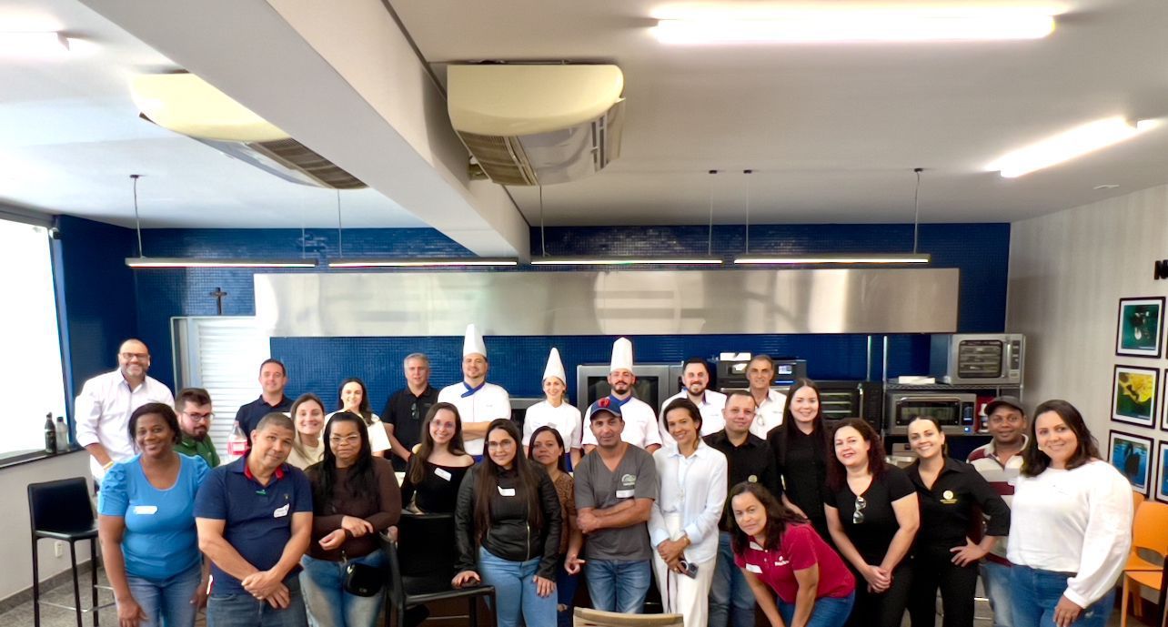 Um grupo de pessoas está posando para uma foto em uma cozinha.