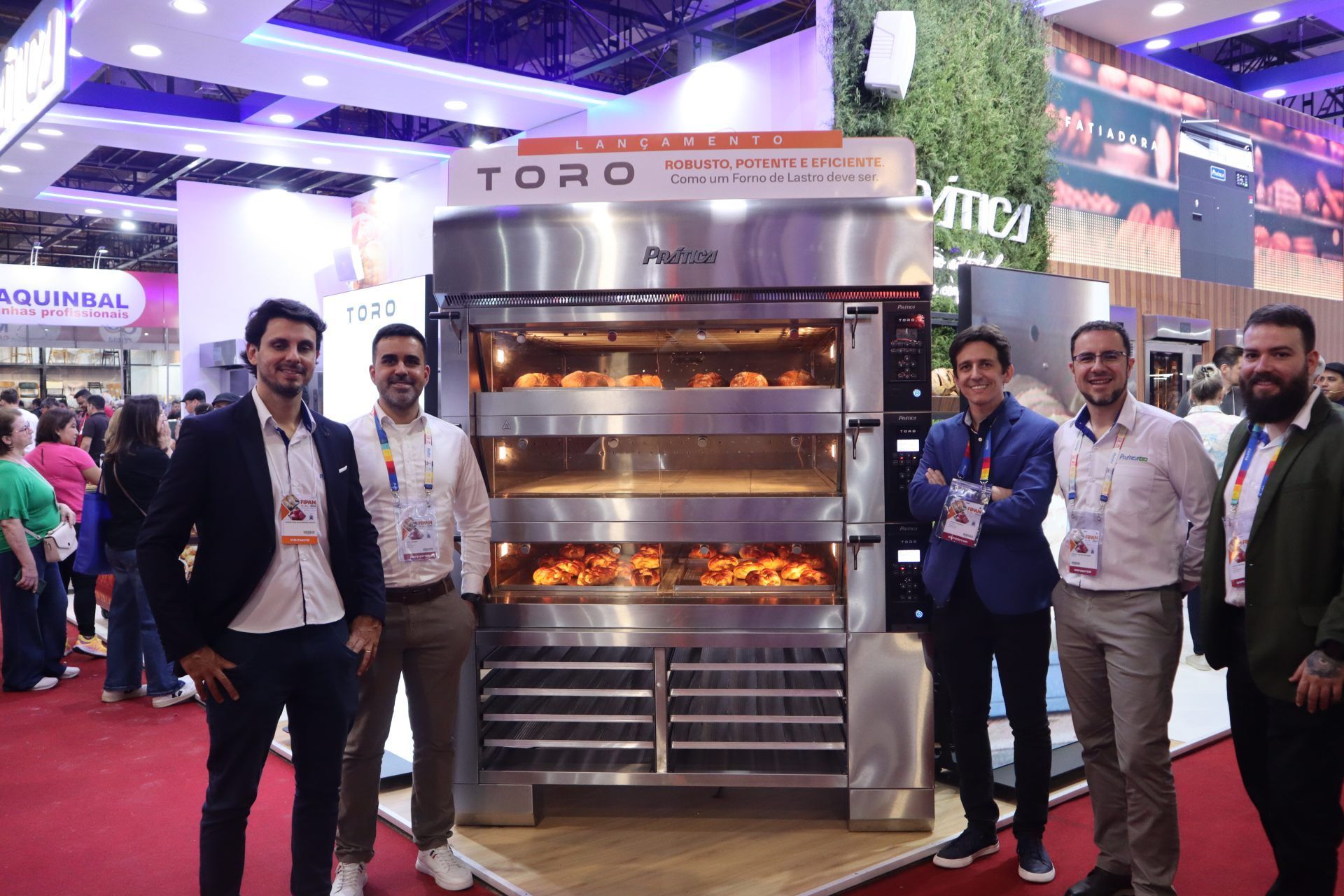 Um grupo de homens está em pé em frente a um grande forno.