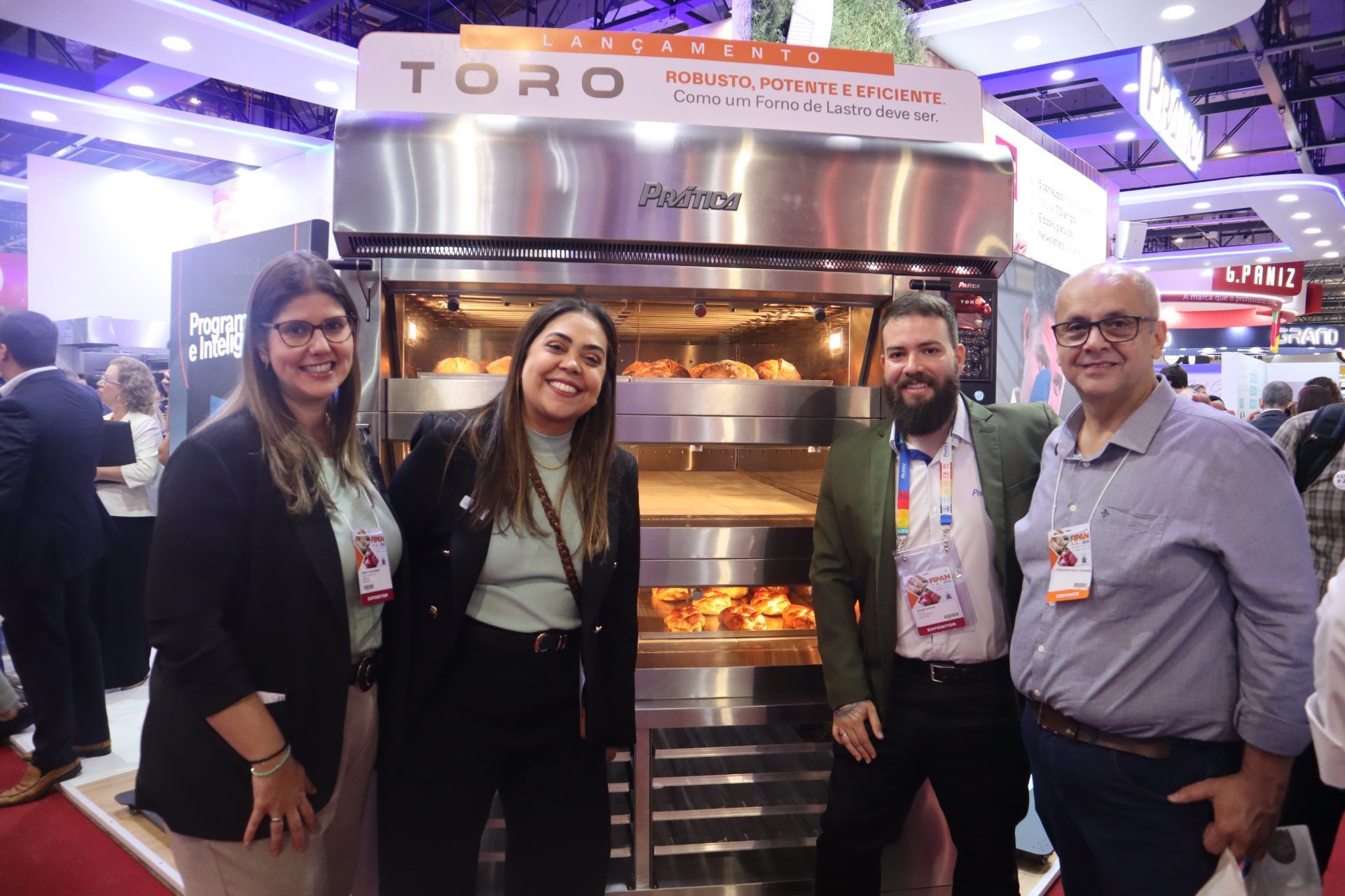 Um grupo de pessoas está posando para uma foto em frente a um forno.