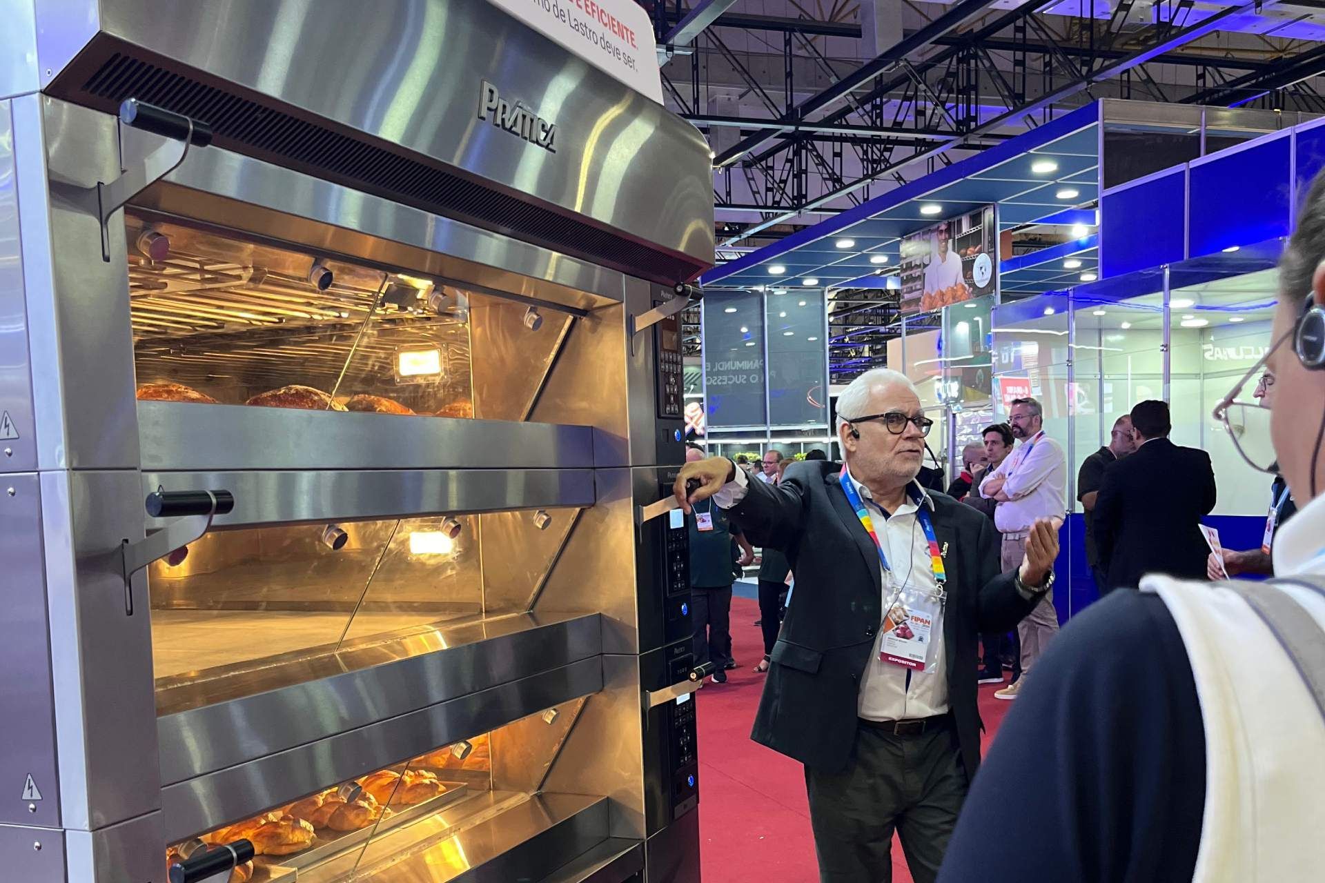 Um homem de terno está parado em frente a um grande forno.