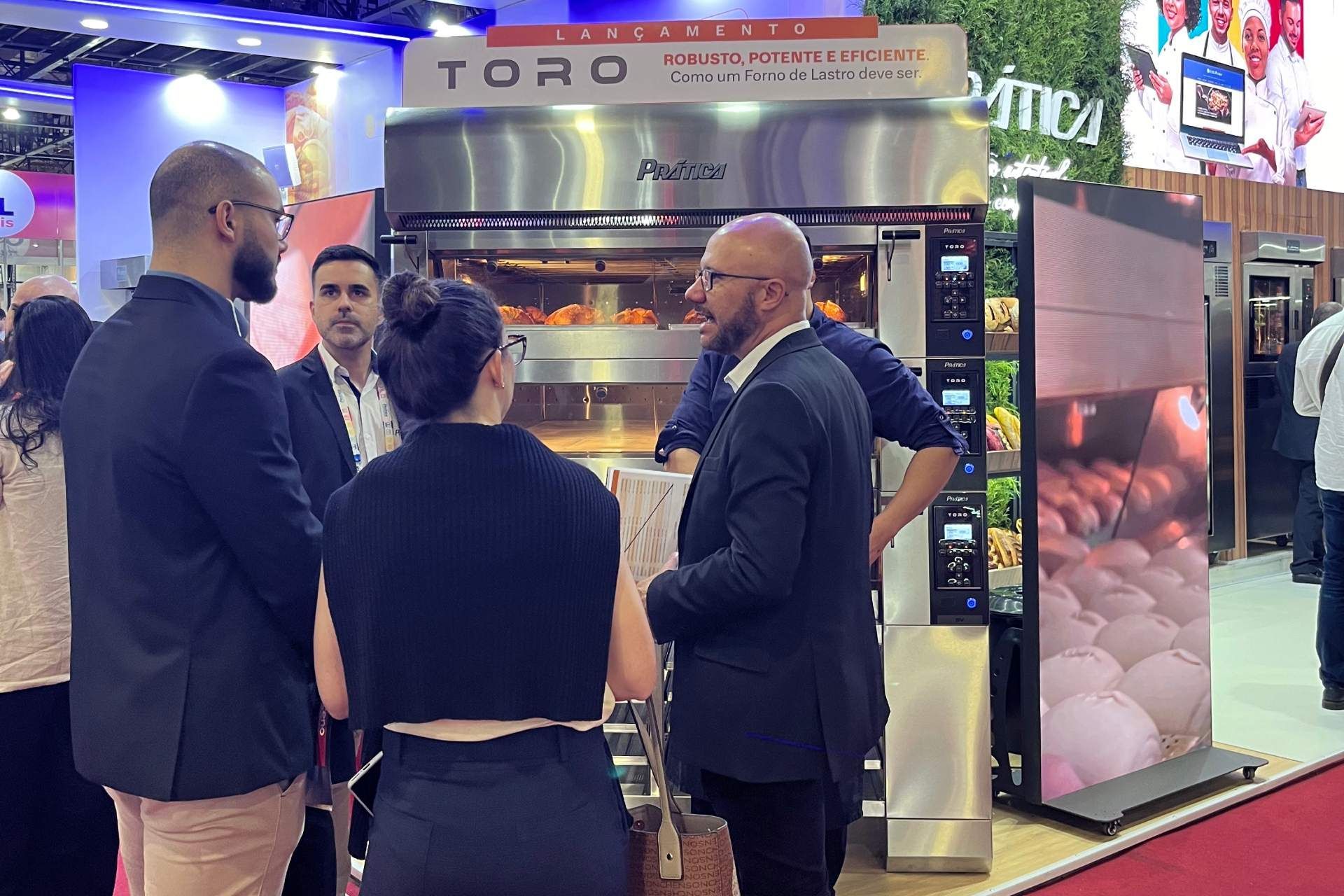 Um grupo de pessoas está em frente a um forno toro.