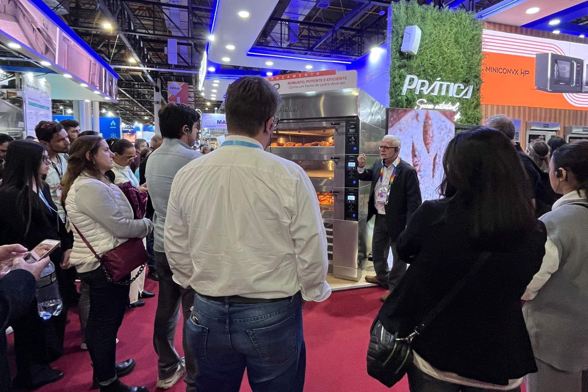 Um grupo de pessoas está em uma sala olhando para uma máquina.