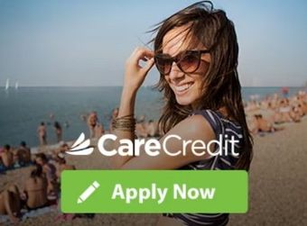 A woman wearing sunglasses is standing on a beach next to a carecredit apply now button