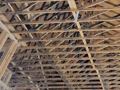 Wooden roof trusses with metal connectors in a new building under construction.