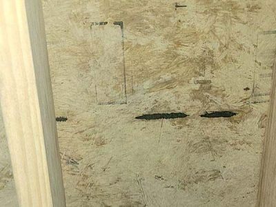 OSB panel with wood framing. Panel shows dark, irregular marks and an inset rectangle.