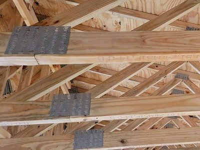 Wooden roof trusses joined with metal connector plates.
