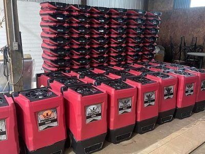 Rows of red and black portable heaters stacked in a warehouse.
