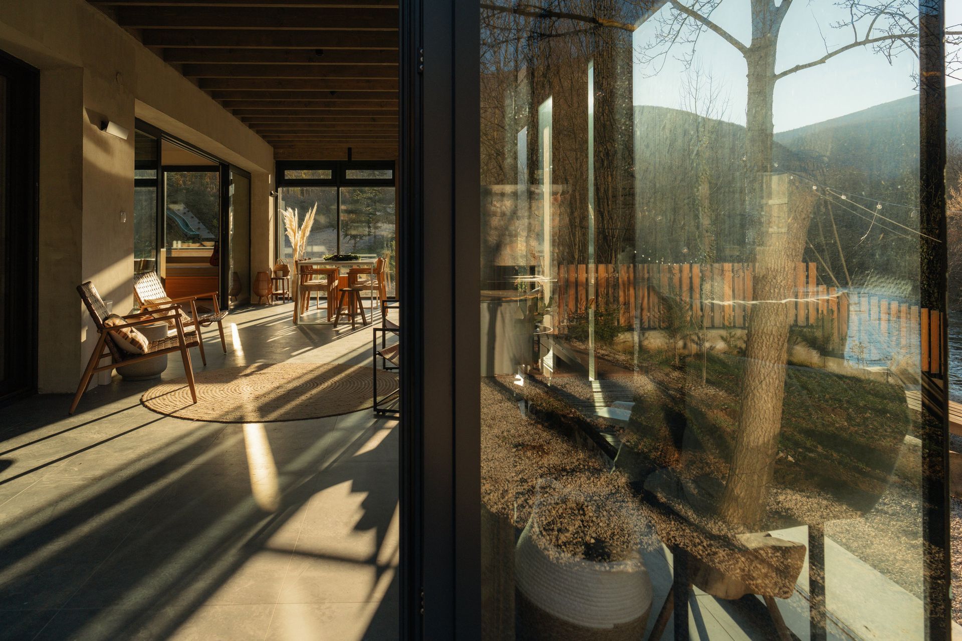 There is a reflection of trees in the window of a house.