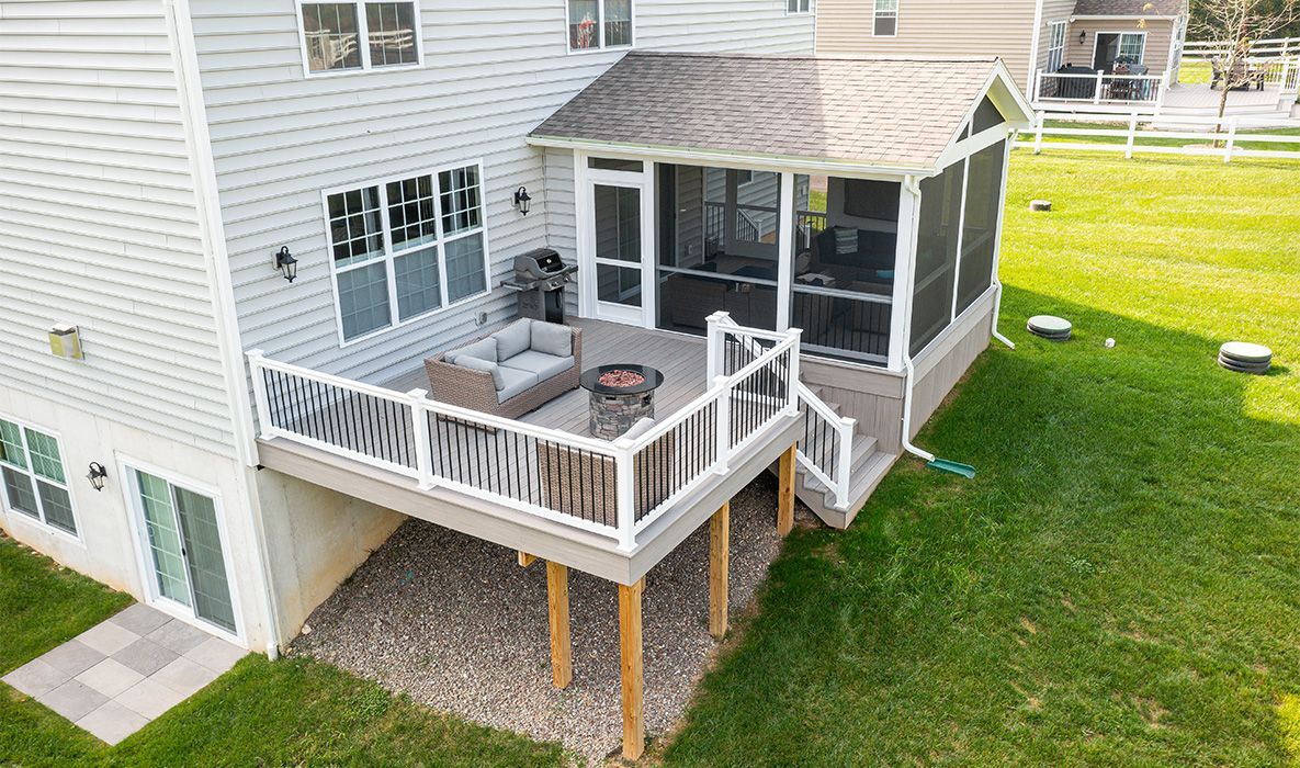 Beige gutter downspout attached to a brick wall.