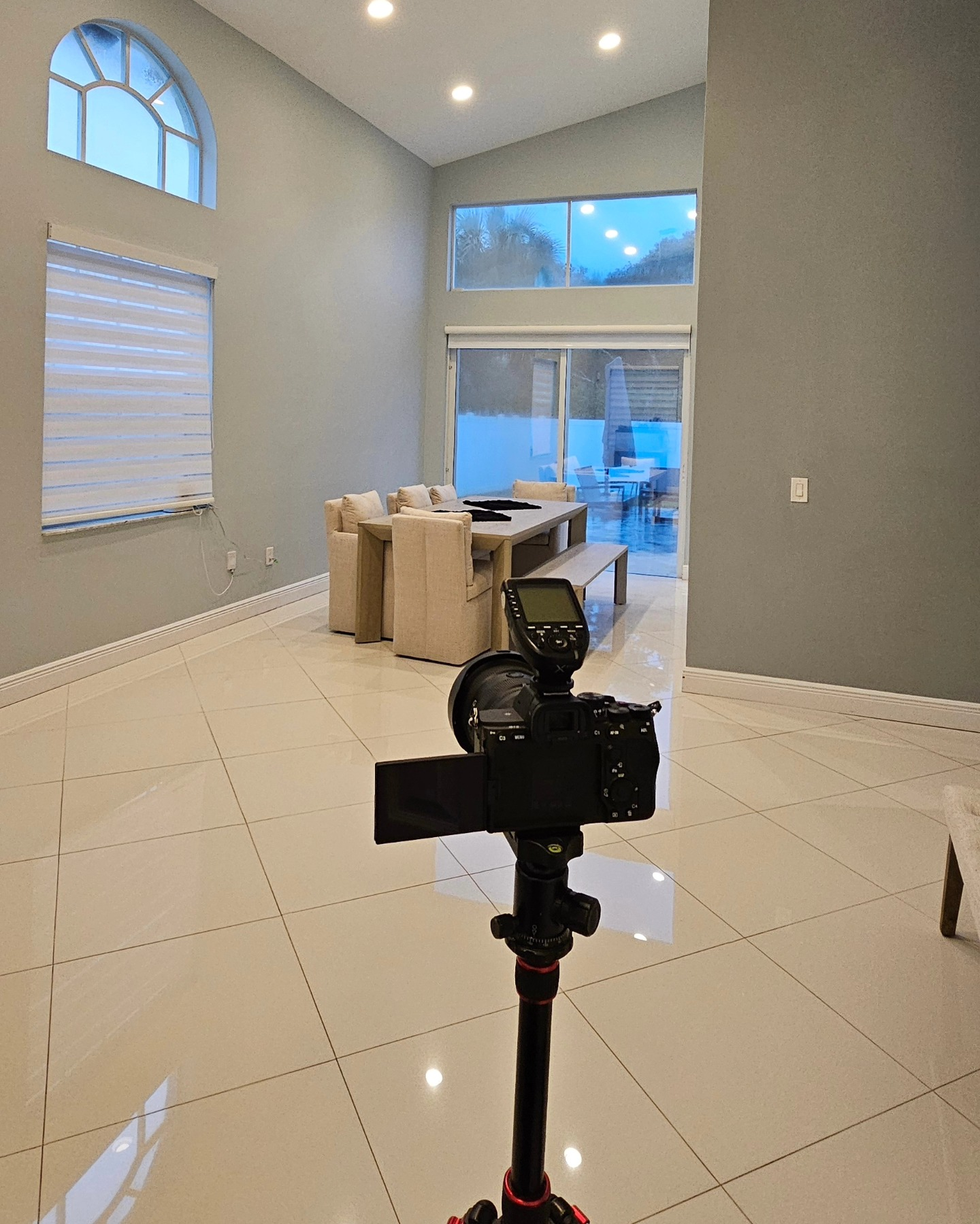 A camera is sitting on a tripod in an empty room