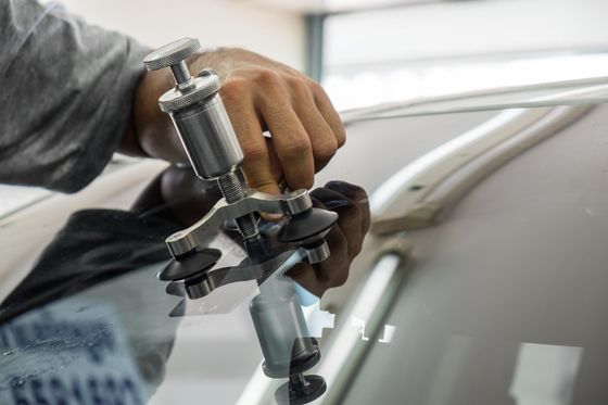 man removing broken windshield