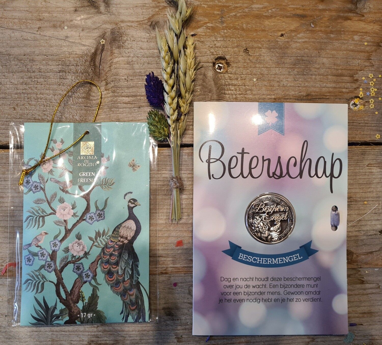 Beterschapscadeaubox met kaart, gedroogde bloemen en een cadeautas met pauwenmotief.