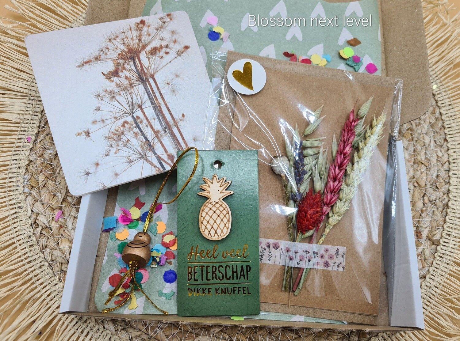 Doos met een arrangement van gedroogde bloemen, een kaartje en een label met een ananas.