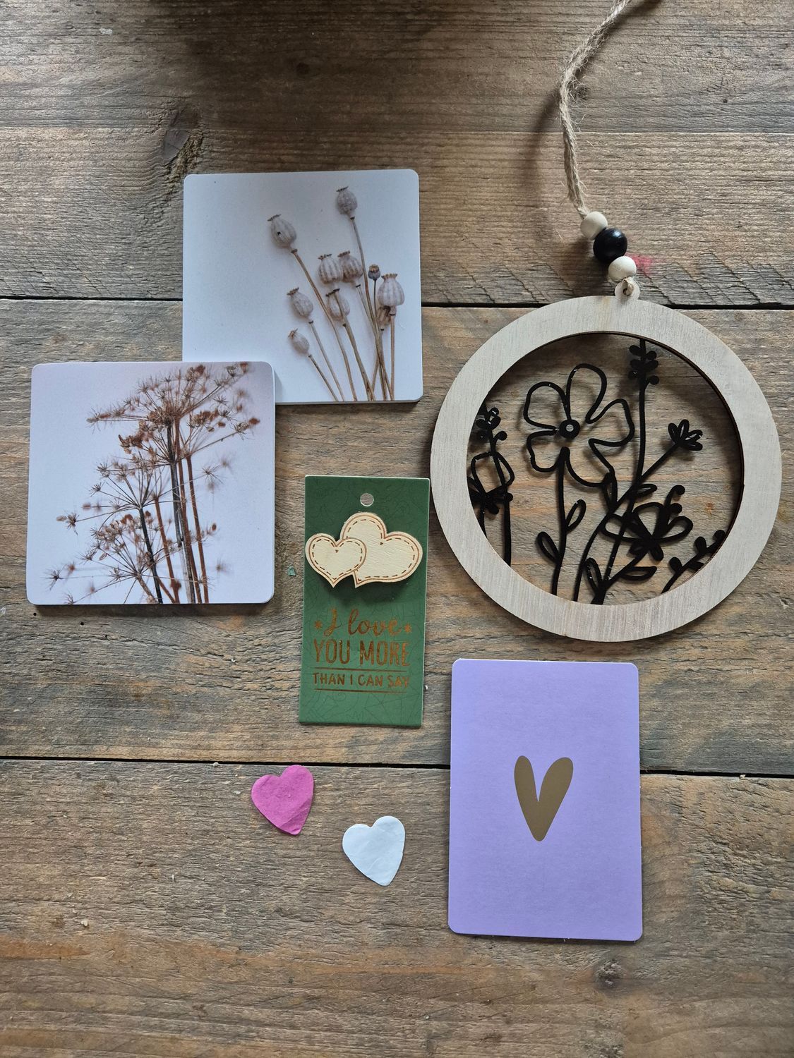 Doos met wenskaarten, wanddecoratie en een hartvormig label. De artikelen zitten in een doos met een hartjespatroon.