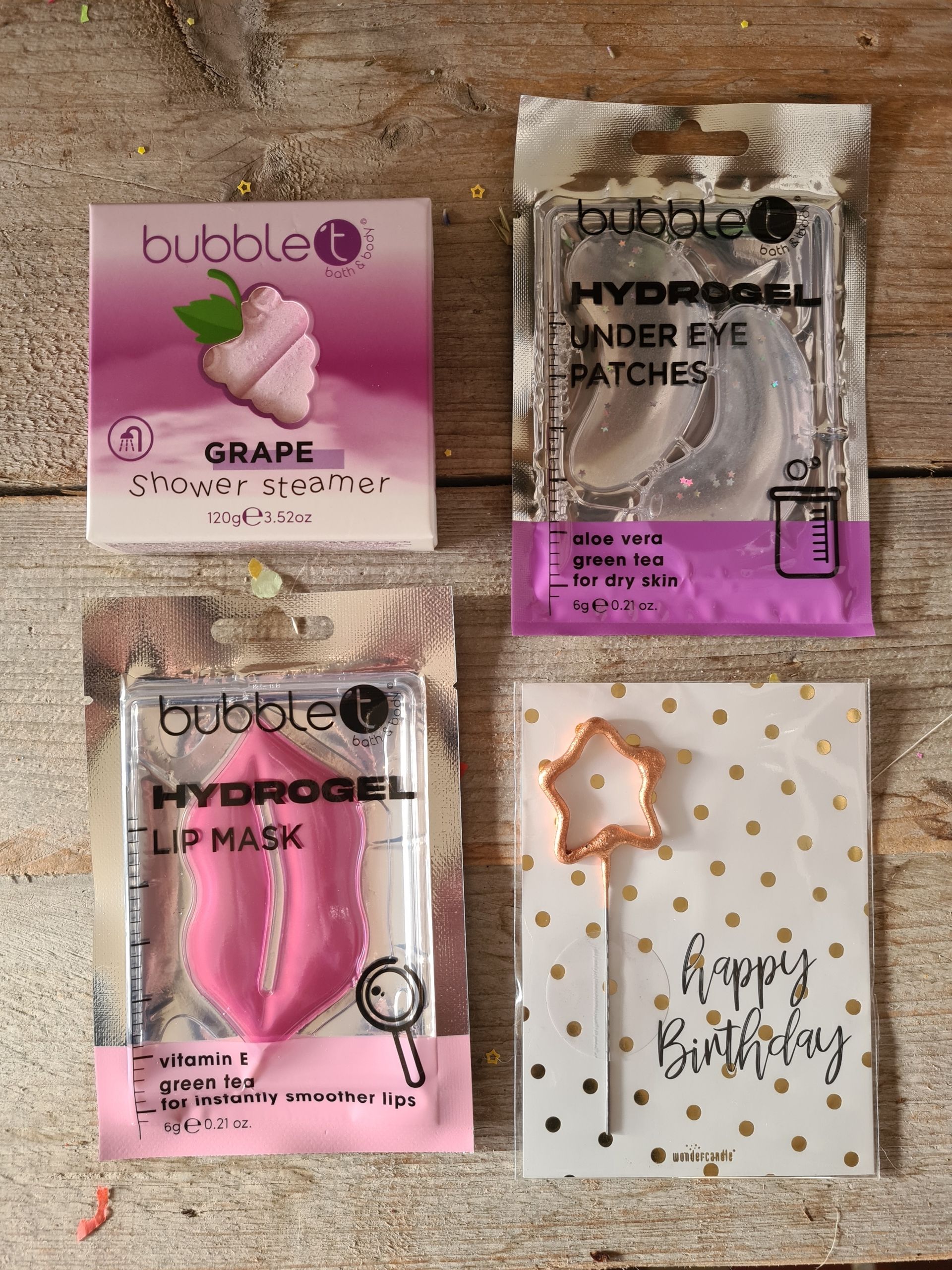 Vier beautyproducten: een gezichtsmasker met druivenextract, oogpatches, een lippenmasker en een verjaardagskaart.