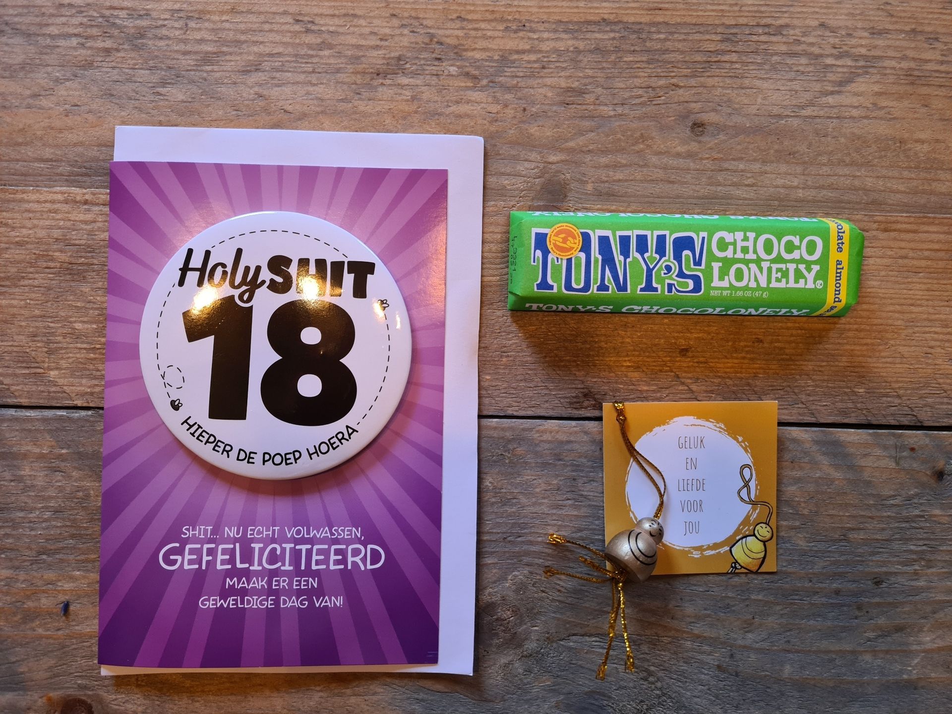 Doos met cadeautjes voor een 18e verjaardag: kaart, chocolade en bedeltje. Tekst bevat onder andere 