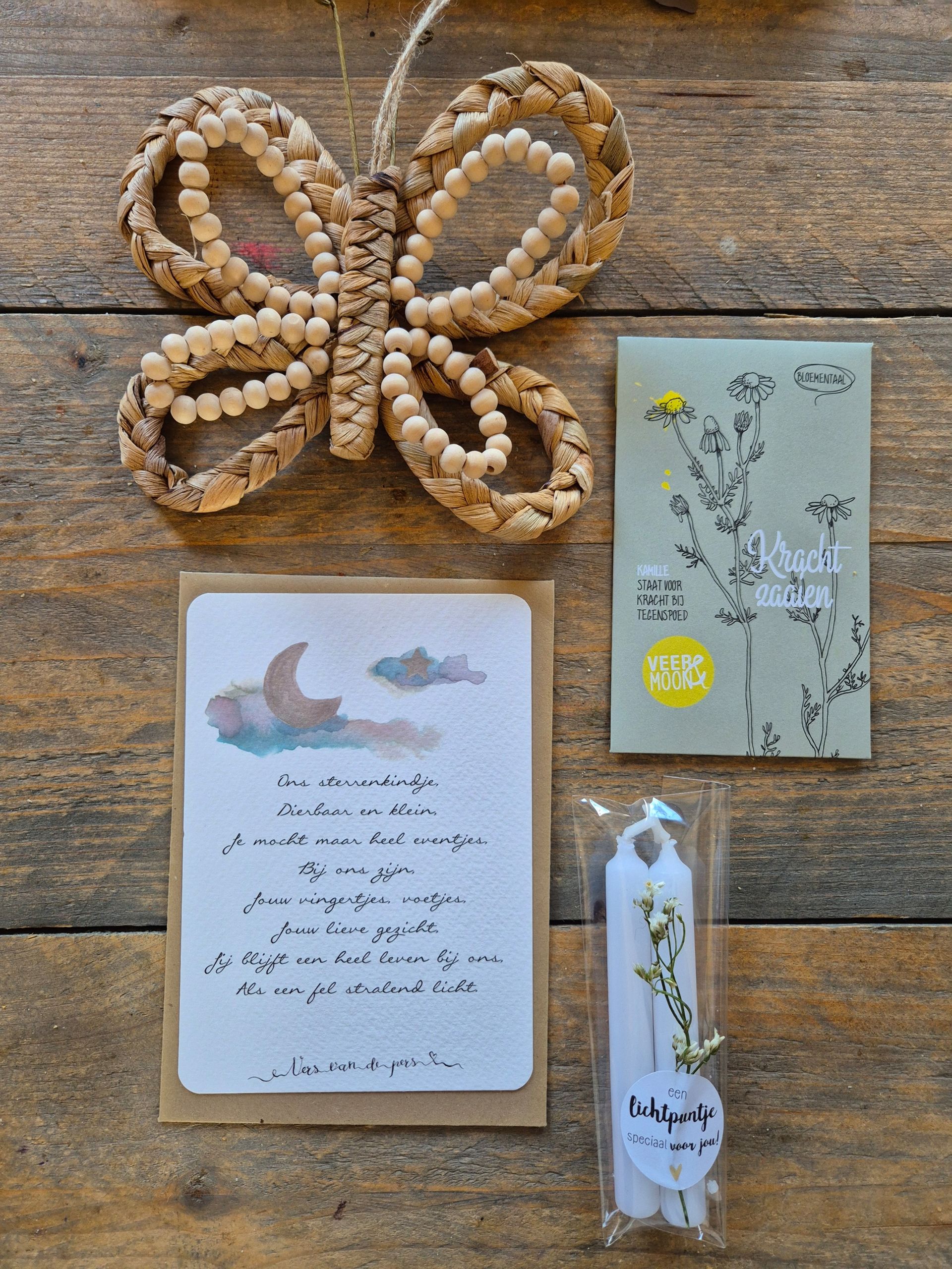 Doos met een kaartje, vlinderdecoratie, een zakje zaadjes en een kaars. De binnenkant van de doos is versierd met roze hartjes.