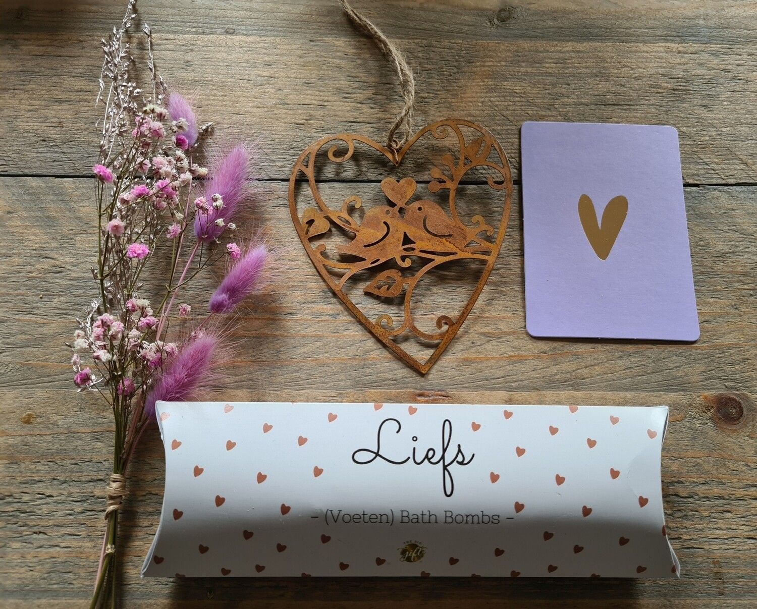 Doos met hartvormige versiering, paars karton, roze bloemen en een rol met de tekst 