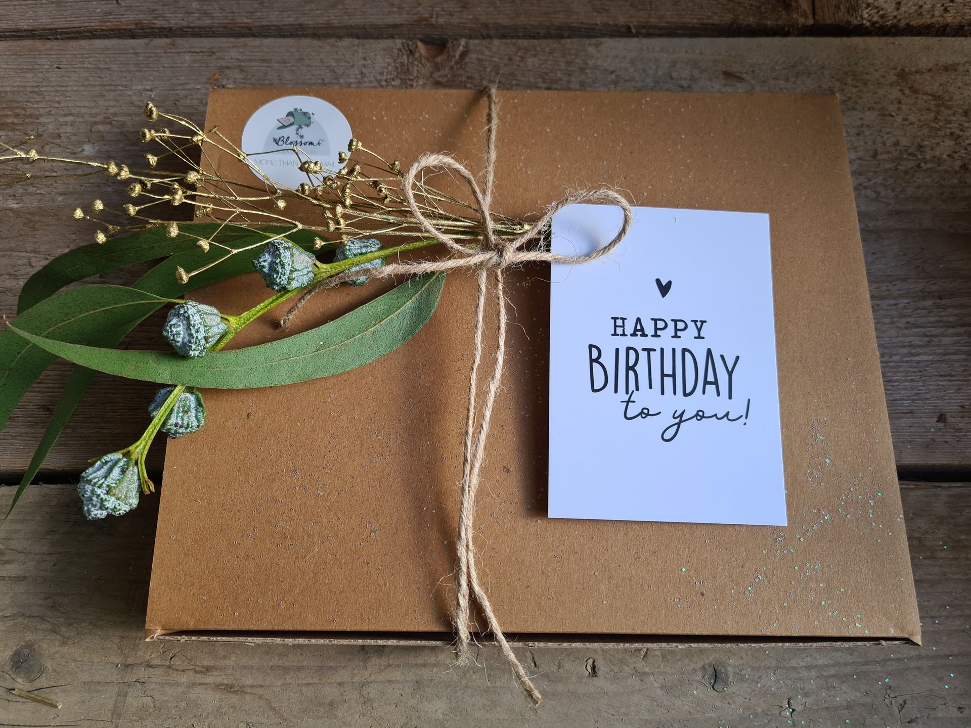Een verjaardagscadeau in een doos, ingepakt met touw, met een kaartje waarop staat 